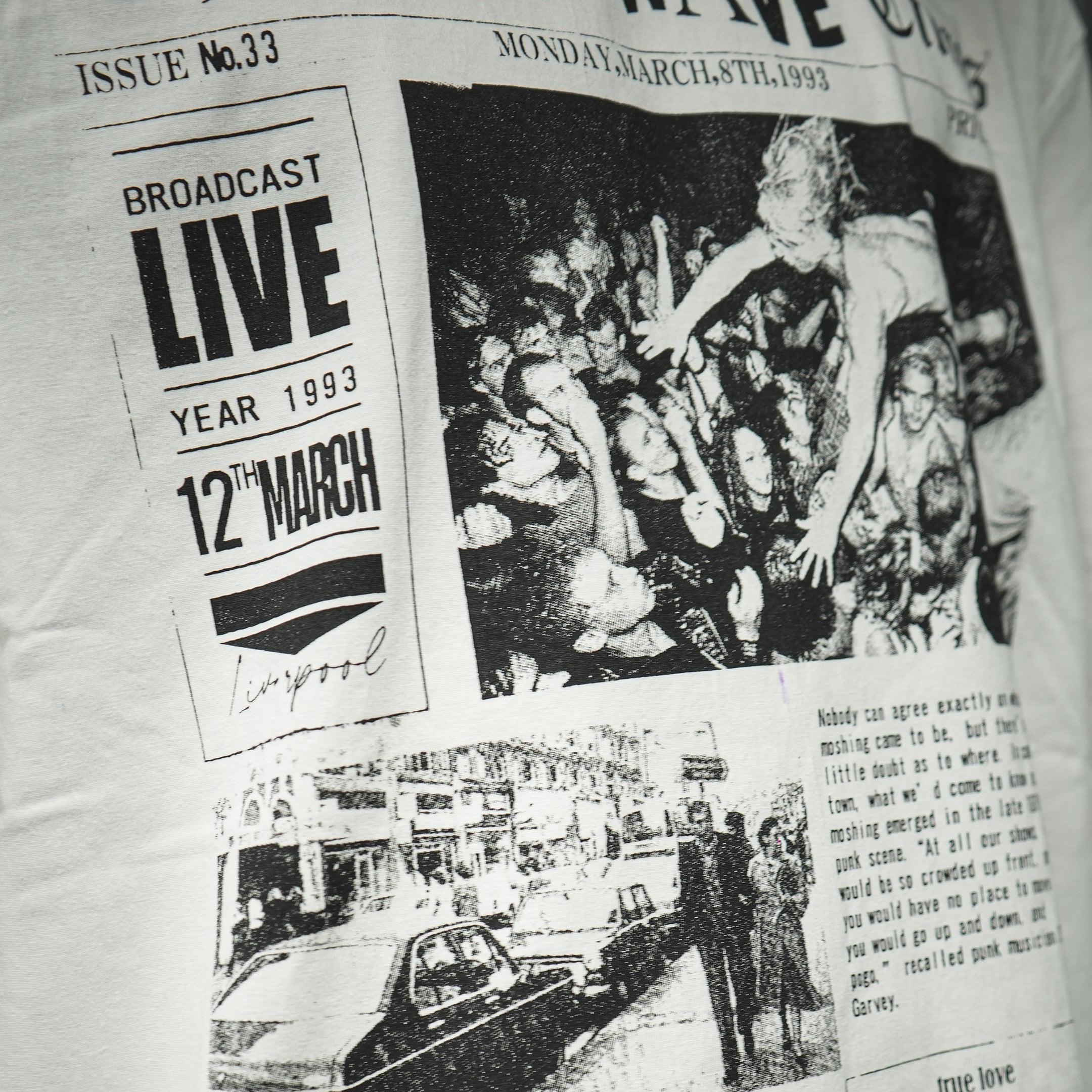Maison Casanova 白のグラフィックTシャツ。フロントに架空の新聞「The NEW WAVE Times」とモッシュする群衆のモノクロ写真プリント。裾に赤いブランドラベル付き。