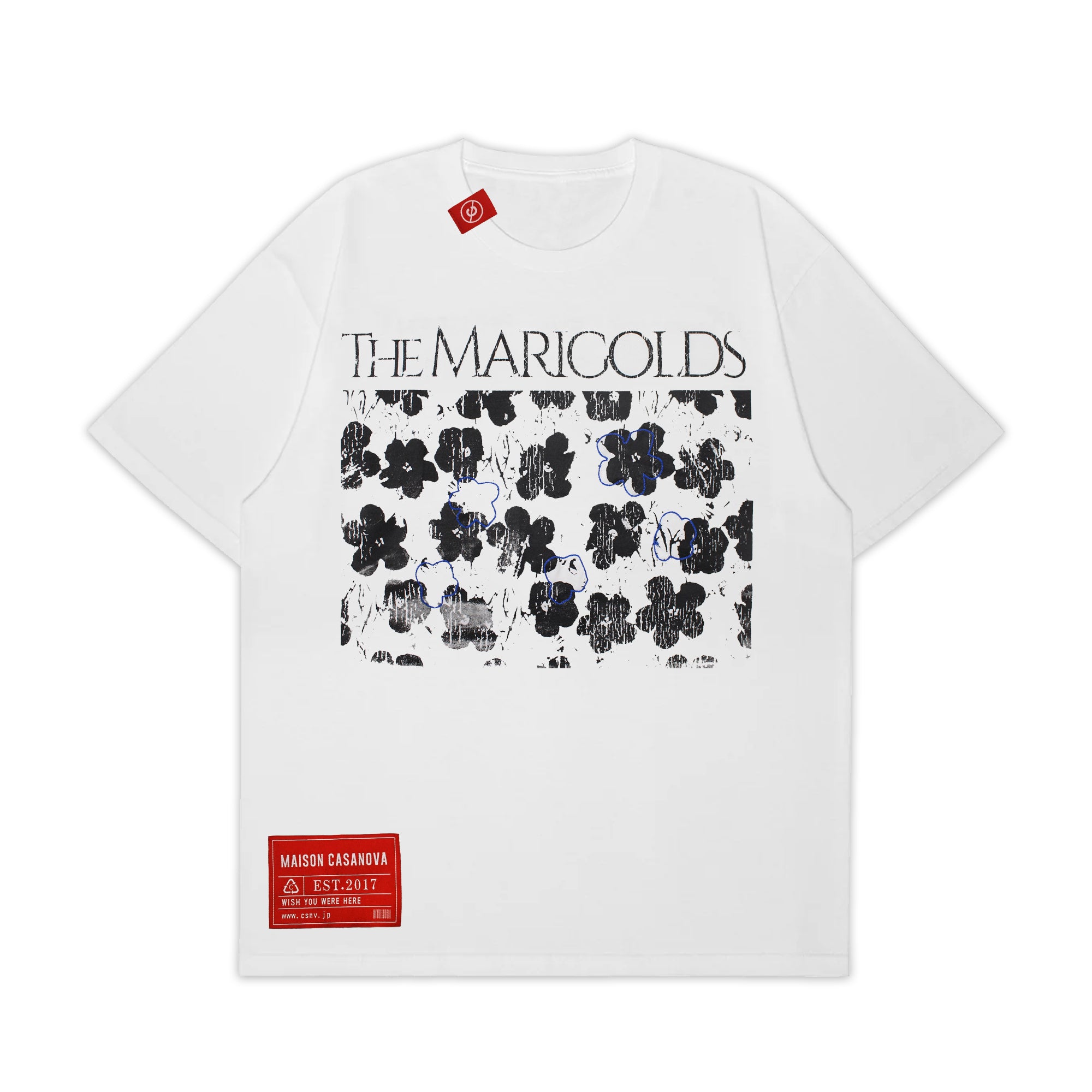 Maison Casanova 白のグラフィックTシャツ。フロントに「THE MARIGOLDS」の文字と、かすれた黒い花柄、青い花の線画プリント。左裾に赤いブランドラベル付き。山本裕典着用