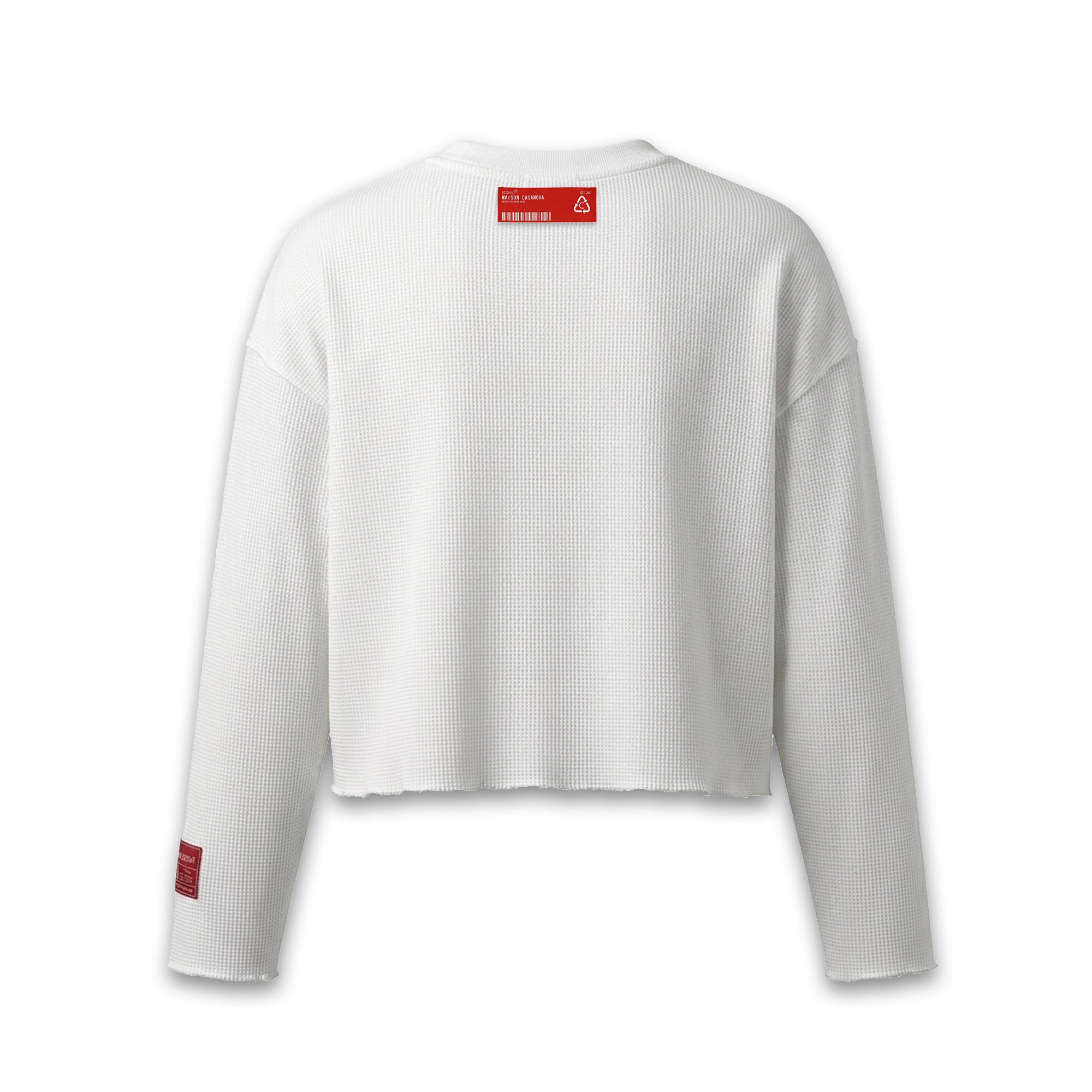 Maison Casanova 白のワッフル編みクロップド長袖Tシャツ。裾は切りっぱなしのカットオフ仕様。首元の右側と左袖口に赤いブランドラベル付き。