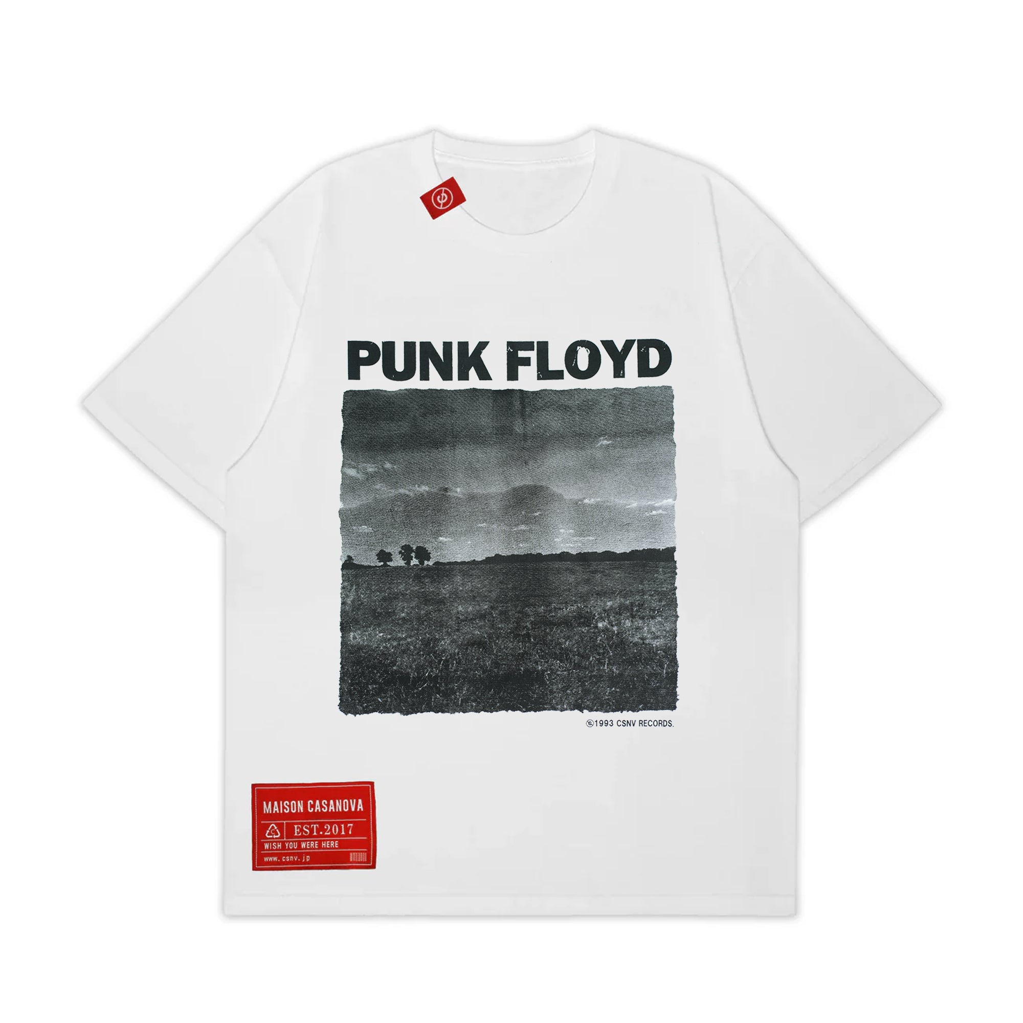 MAISON CASANOVAの白い半袖Tシャツ。フロントに太い黒字で「PUNK FLOYD」のテキスト、その下にざらつきのあるモノクロの風景写真（野原と遠くの木々）が大きくプリントされている。グラフィックの右下には「© 1993 CSNV RECORDS」の小さな文字。左下には赤い長方形のブランドパッチ。